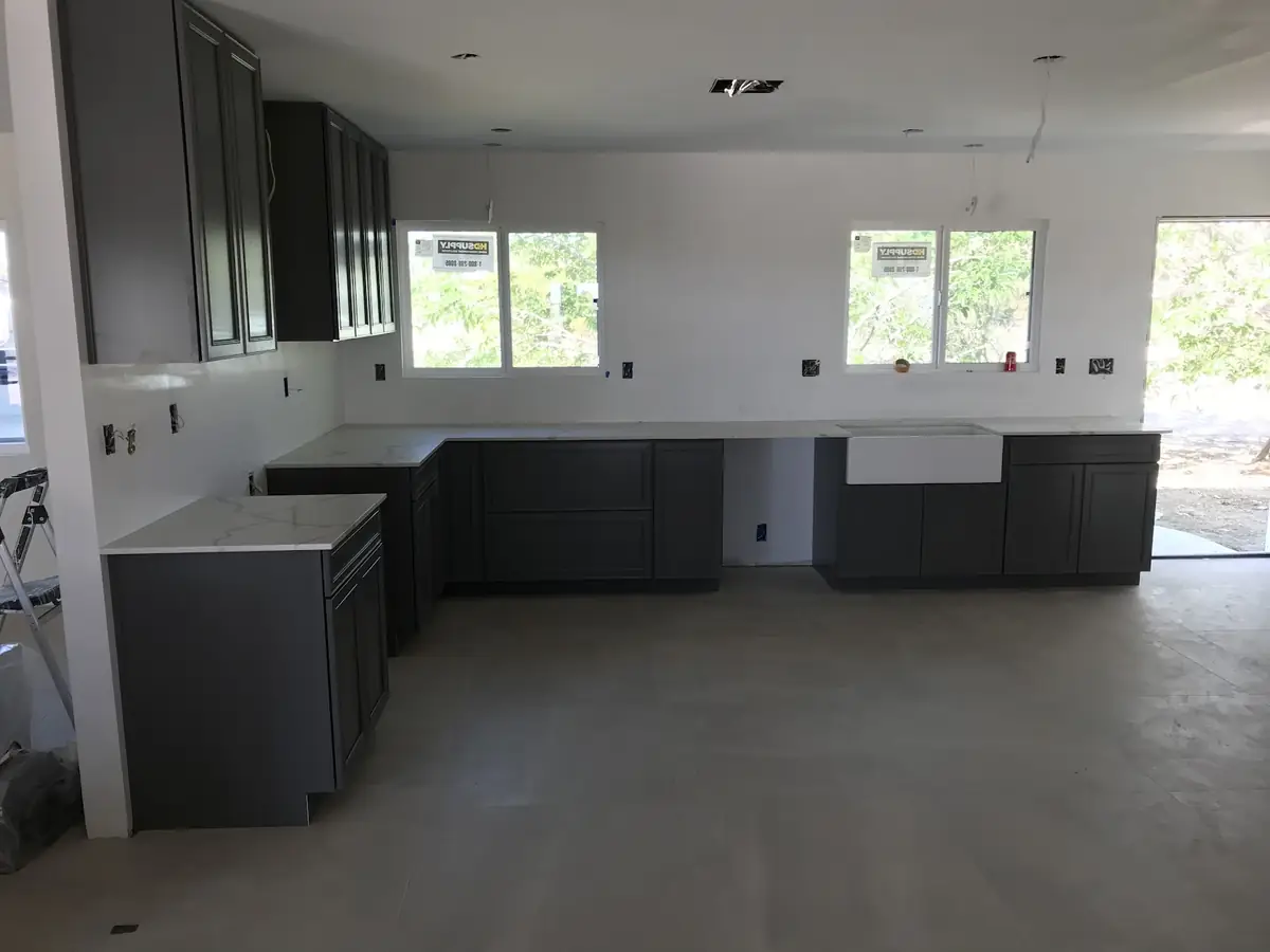 Kitchen fit-out with shaker cabinets, quartz counters and a farmhouse sink